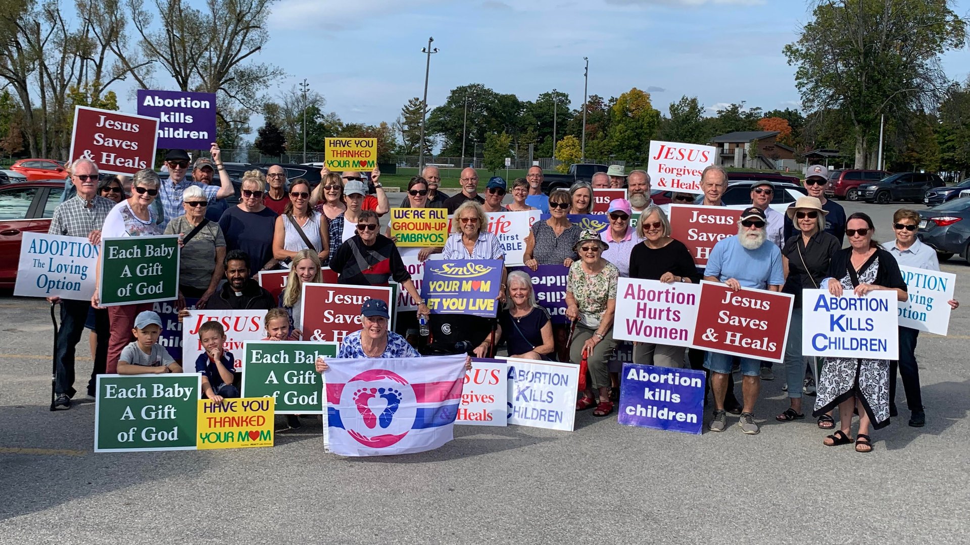 Orillia Life Chain 40 participants posing in a parking lot with Anti-abortion signs